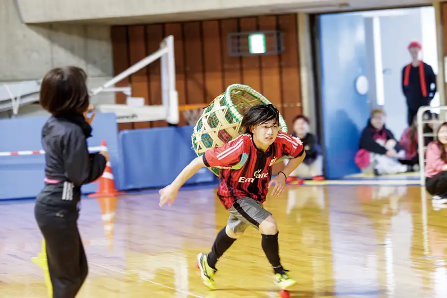 カゴを背負って走る学生