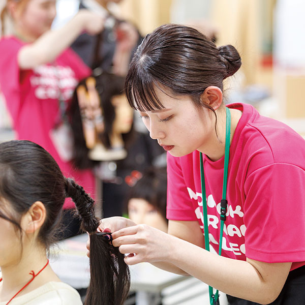 ヘアアレンジをする学生スタッフ