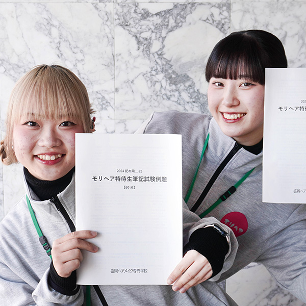 特待生対策講座の冊子を持つ女子学生2名