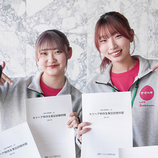 特待生対策講座の冊子を持つ女子学生2名