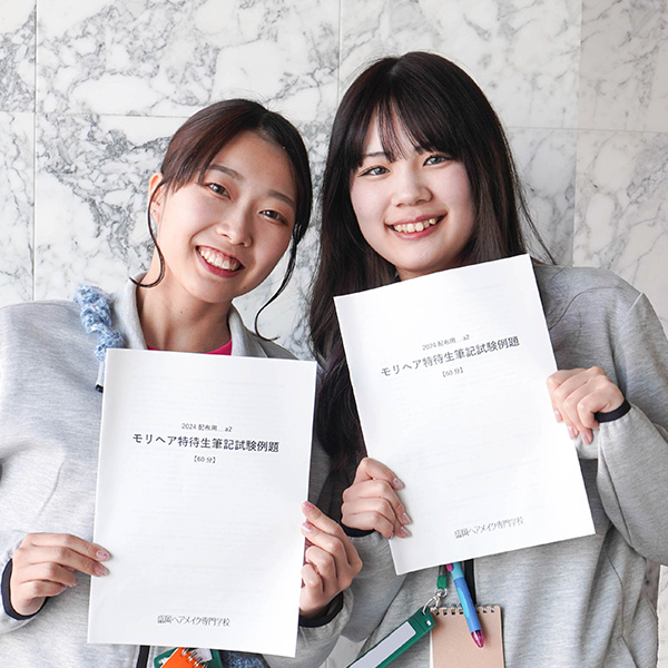 特待生対策講座の冊子を持つ女子学生2名