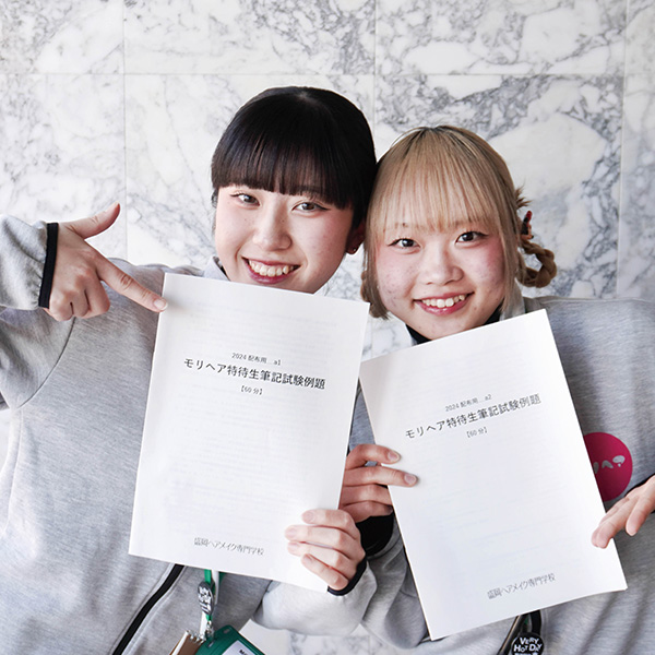 特待生対策講座の冊子を持つ女子学生2名