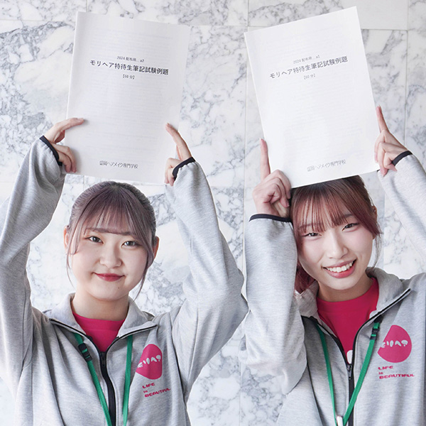 特待生対策講座の冊子を持つ女子学生2名