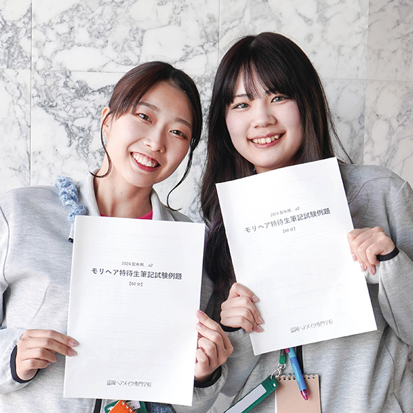 特待生対策講座の冊子を持つ女子学生2名