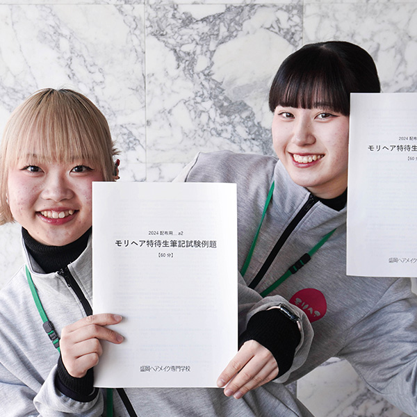 特待生対策講座の冊子を持つ女子学生2名