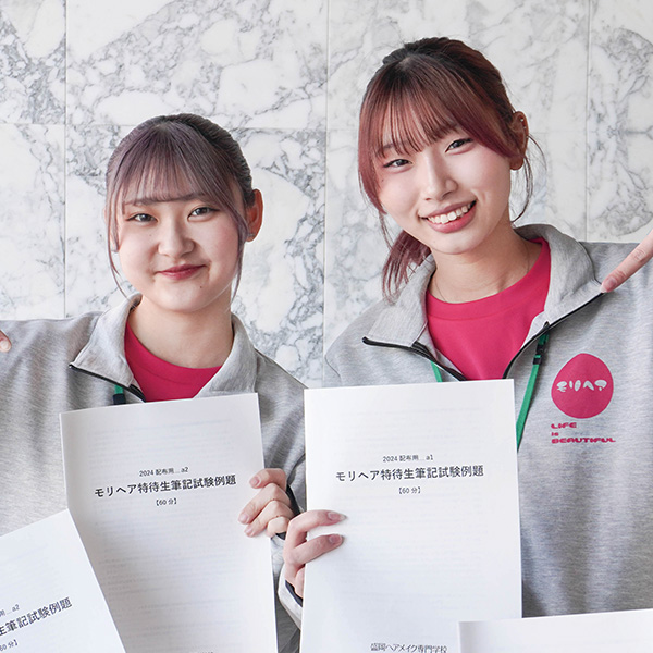 特待生対策講座の冊子を持つ女子学生2名