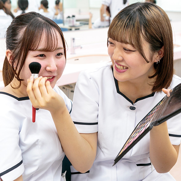 メイクパレットを持ち、メイクブラシを頬にあてている様子