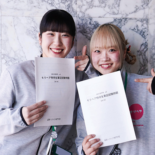 特待生対策講座の冊子を持つ女子学生2名